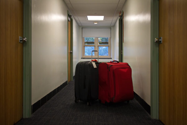 Two,Suitcases,Waiting,Outside,In,The,Dorm,Hallway,On,Move