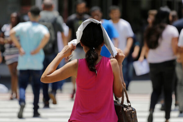 Woman,Protect,Herself,From,The,Hot,Sun,While,Walks,In